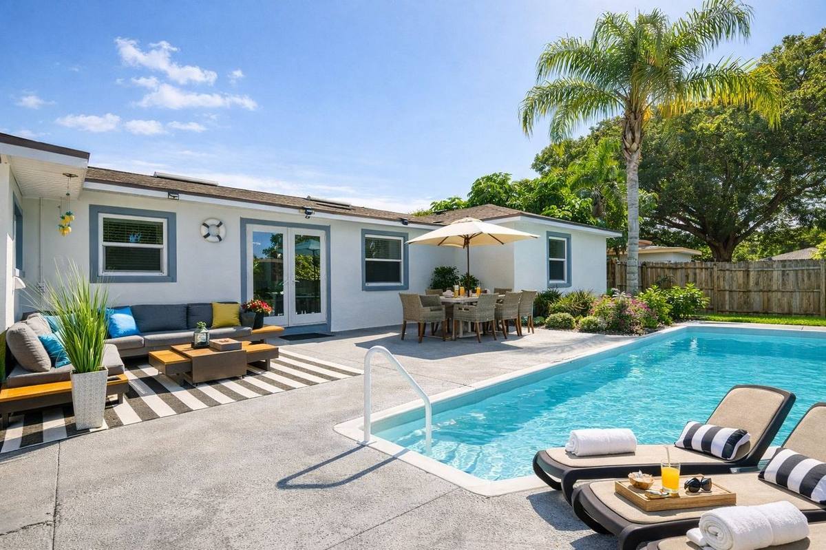 Daytime view of heated pool, lounge chairs and patio at Clearwater vacation home